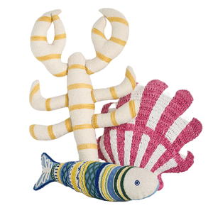 A set of knitted toys depicting a lobster with yellow stripes, a colorful fish, and a pink and white shell.