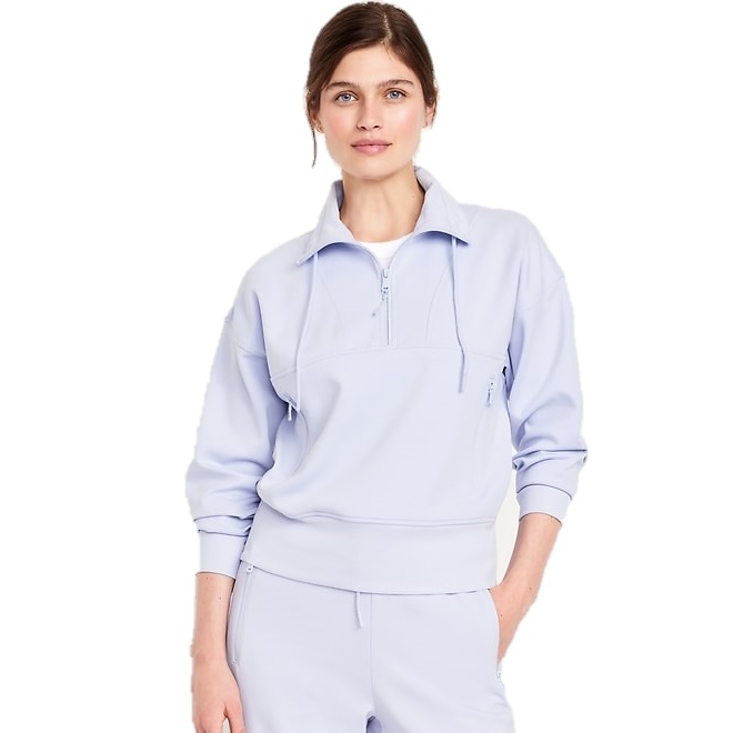 A woman is wearing a light blue zip-up pullover with drawstrings and matching jogger pants, both featuring a relaxed fit.