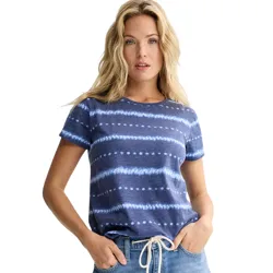 A woman wears a short-sleeve navy blue T-shirt with white horizontal tie-dye stripes, paired with light blue jeans featuring a white drawstring.