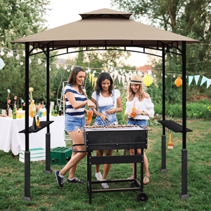 Three women barbecue under a gazebo, with party decorations and a beverage table in the background.