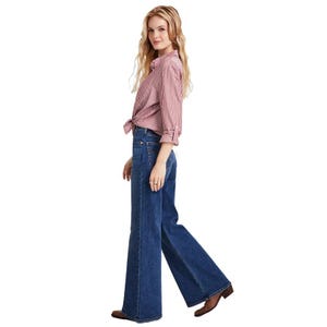 Levi's high-rise flare-leg jeans in dark blue denim with a fitted waist and flared hem, styled with a red and white striped shirt.