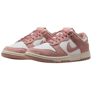 A pair of pink and white Nike Dunk low-top sneakers with suede accents and distinctive Nike branding on the side.