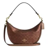 A brown Coach shoulder bag with a crescent shape, features the signature monogram pattern, gold-tone hardware, a detachable strap, and a leather tag.
