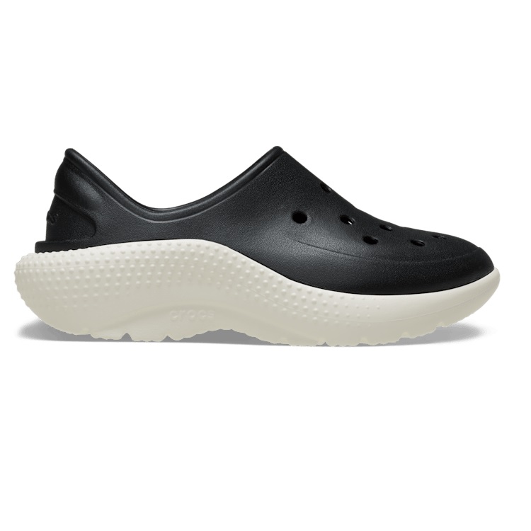 Black slip-on Crocs with a sleek design and perforated holes for breathability, featuring a thick, white textured sole for added comfort and style.