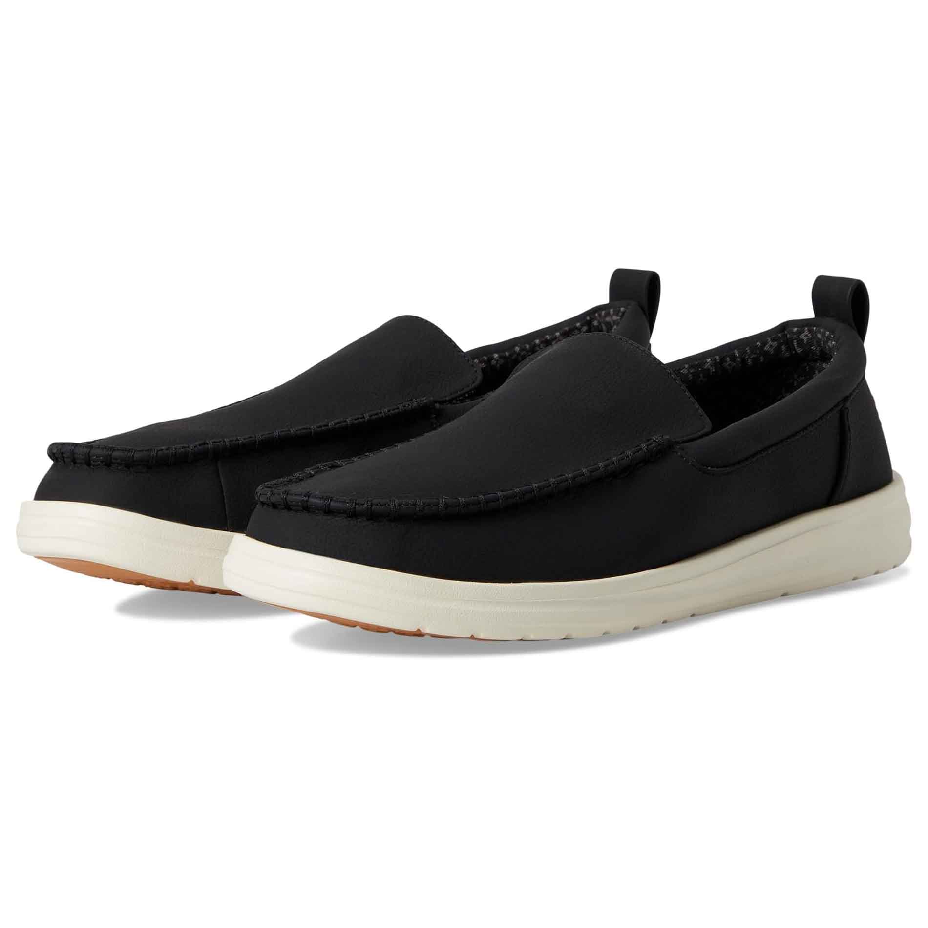 Hey Dude Men's Loafers feature a black upper with moccasin-style stitching, white soles for casual appeal, and pull tabs for easy wear. They have a comfortable, laid-back design suitable for everyday use.