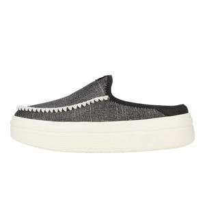 A slip-on shoe with a black fabric upper and white decorative stitching along the edge, featuring a thick white platform sole.
