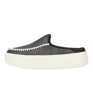A slip-on shoe with a black fabric upper and white decorative stitching along the edge, featuring a thick white platform sole.