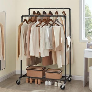 A clothing rack with various hanging garments, shoes, and storage boxes.