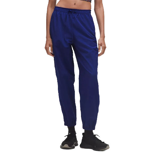 Blue athletic pants with an elastic waistband and cuffs, worn with black sneakers.