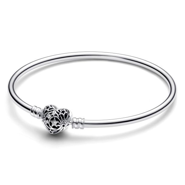 The Pandora Celestial Bangle Bracelet features a sleek silver band with an intricate heart-shaped charm adorned with star patterns. It's elegant and minimalist in design, suitable for various occasions.