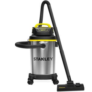 Stanley shop vacuum with stainless steel body, yellow and black accents, 4.0 horsepower motor, and a flexible hose attached to a floor nozzle. It features a handle on top and caster wheels for mobility.
