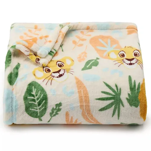 A soft, folded blanket featuring a playful lion cub and colorful leaves in a jungle-themed design.