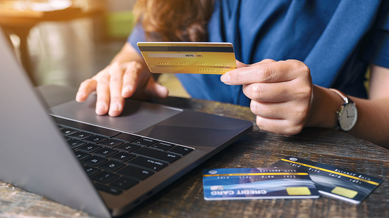 woman paying with credit card on laptop