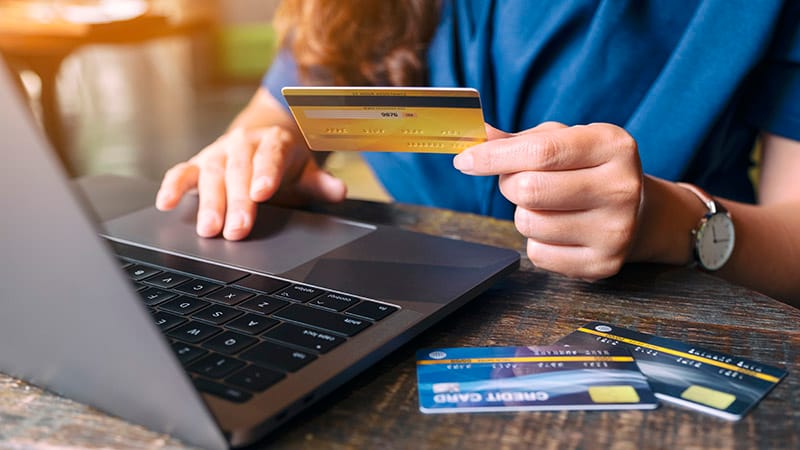 woman paying with credit card on laptop