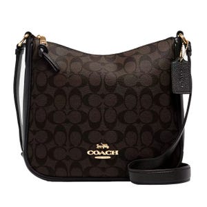 Coach crossbody bag with a dark brown signature pattern and black leather trim, featuring a gold-tone logo and a matching leather tag.