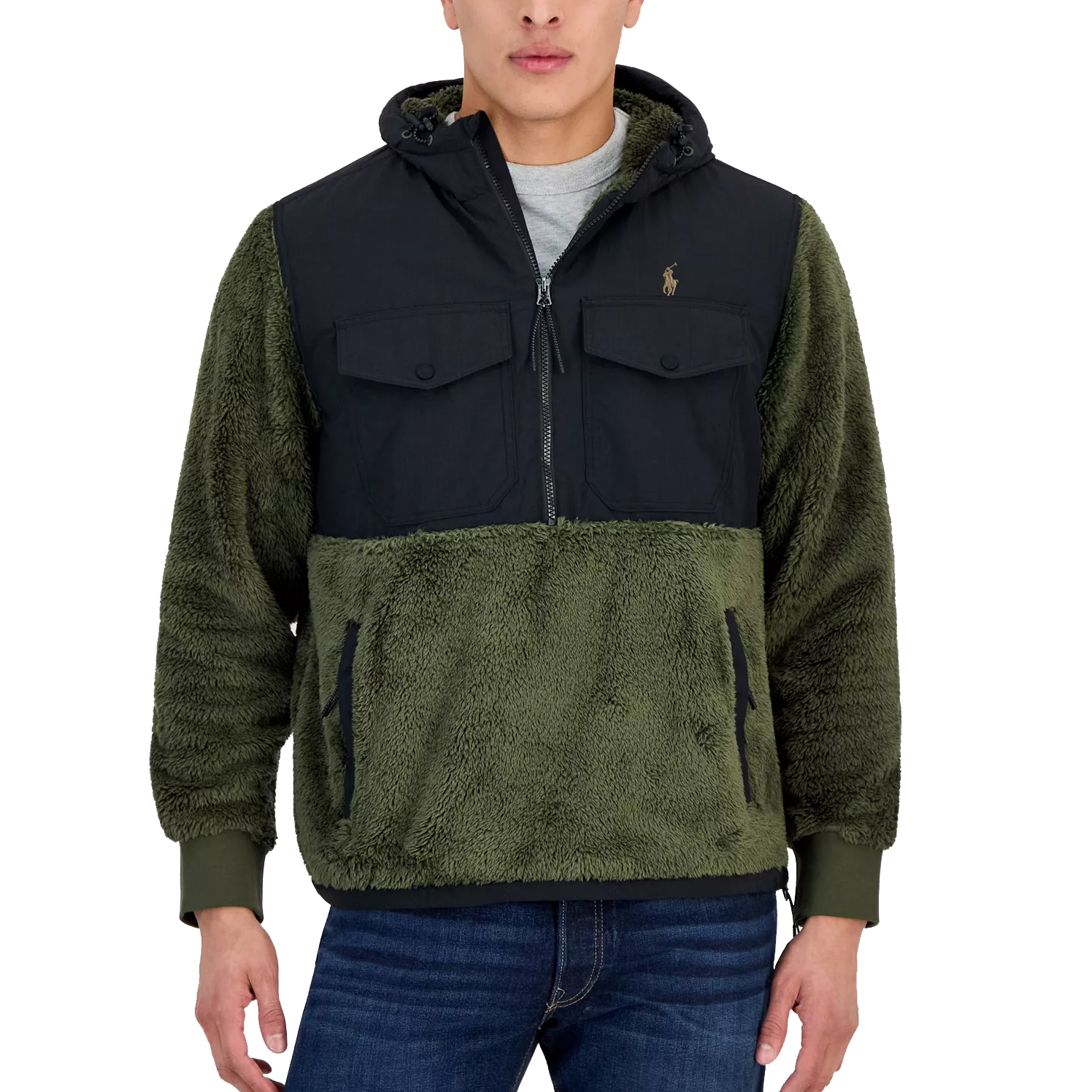 A green and black jacket featuring a plush sherpa design with a hood, dual chest pockets, and a zipper closure. Suitable for cold weather, paired with jeans.