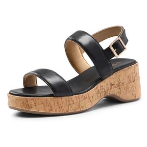 A black, open-toe sandal with a cork platform and block heel, featuring two straps and an adjustable ankle buckle.