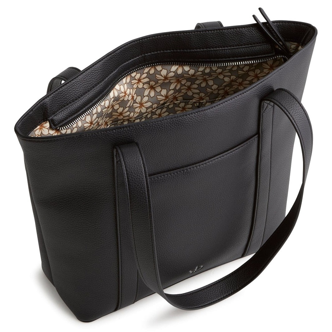 Black leather tote bag with dual handles, featuring a floral pattern interior lining and an exterior pocket.