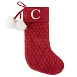 A red quilted Christmas stocking featuring the letter \“C\“ on the cuff, decorated with white faux fur pom-poms and a hanging loop.