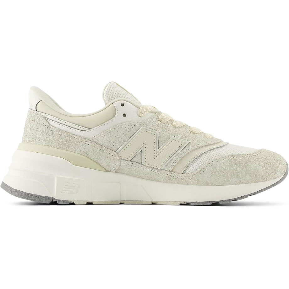 The New Balance 997 sneakers feature a clean, cream color scheme with suede and mesh detailing, a thick rubber sole, and the signature \“N\“ logo on the side, offering a classic, minimalist look.