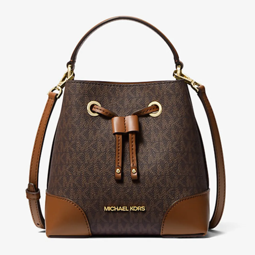 Brown Michael Kors bucket bag with a monogram print, trimmed with tan leather, featuring a drawstring closure, gold-tone hardware, and a detachable shoulder strap.