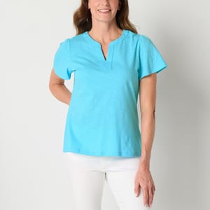 A woman wearing a turquoise V-neck t-shirt and white pants.