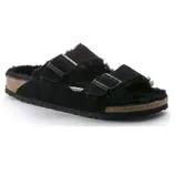 A black suede sandal with a cork sole and two adjustable straps, featuring a fuzzy interior lining.