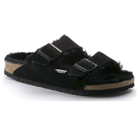 A black suede sandal with a cork sole and two adjustable straps, featuring a fuzzy interior lining.