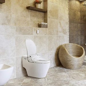 A modern toilet with bidet functionality next to a bidet and a round wicker basket.