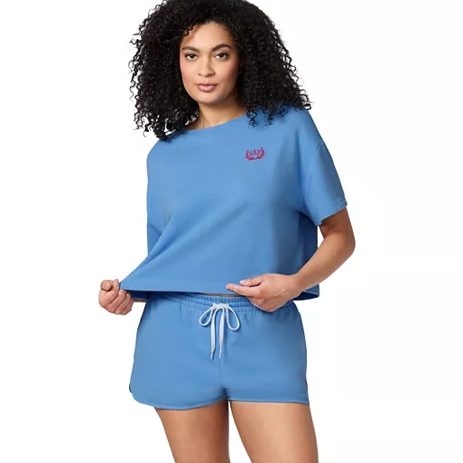 A woman is wearing a casual blue matching set consisting of a short-sleeved T-shirt and drawstring shorts.
