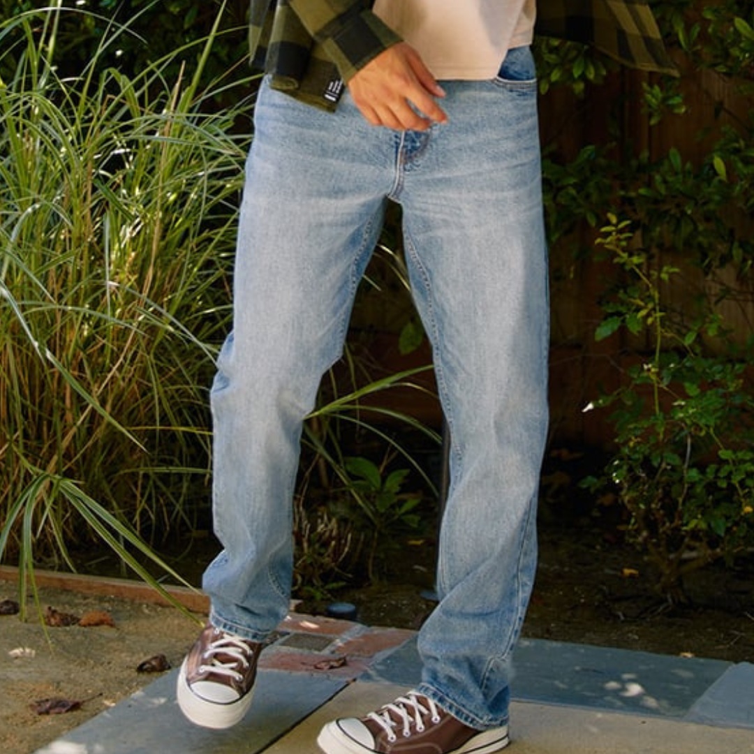 Light blue straight-leg jeans, paired with a flannel shirt and brown low-top sneakers.