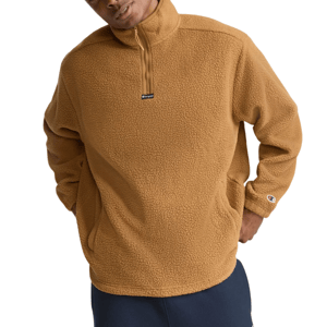A person wears a brown fleece pullover with a quarter-zip collar and a small logo on the sleeve.