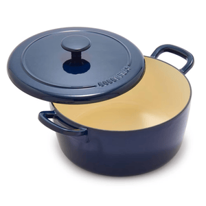 A blue enameled cast iron Dutch oven with handles and a matching lid, featuring an off-white interior.