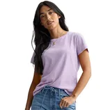 A woman wearing a light purple t-shirt and blue jeans, standing with a casual pose.