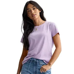 A woman wearing a light purple t-shirt and blue jeans, standing with a casual pose.