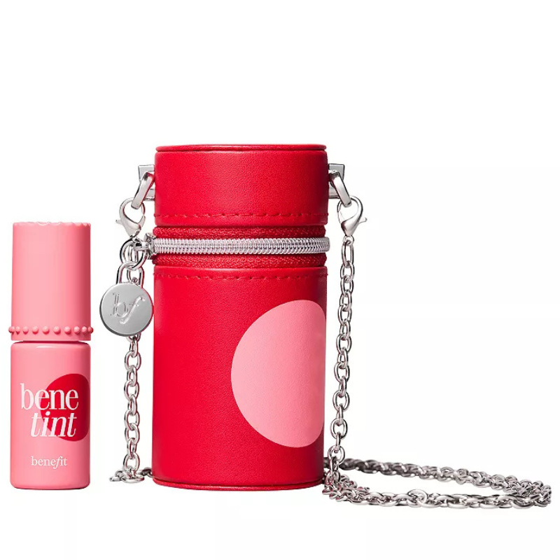 A compact red carry case with a chain is shown alongside a small bottle of Benefit Cosmetics Benetint, a liquid lip and cheek stain.