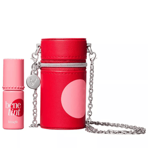 A compact red carry case with a chain is shown alongside a small bottle of Benefit Cosmetics Benetint, a liquid lip and cheek stain.