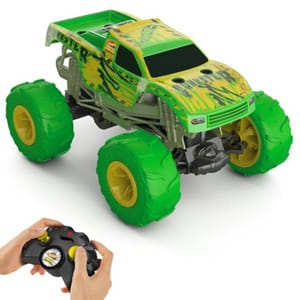 A green RC Hot Wheels Monster Truck with large yellow and green tires, featuring a rugged design and black graphics, is controlled by an included black remote with yellow joysticks.