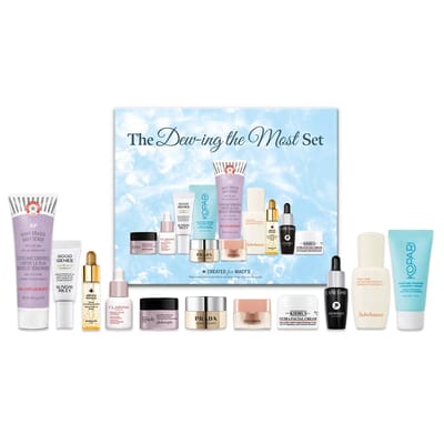 The \“Dew-ing the Most Set\“ includes skincare products like First Aid Beauty KP Bump Eraser, Sunday Riley Good Genes, Clarins cream, Philosophy moisturizer, Prada cream, Lancôme Génifique, Kiehl's Ultra Facial Cream, Sulwhasoo, and Kopari moisturizer.