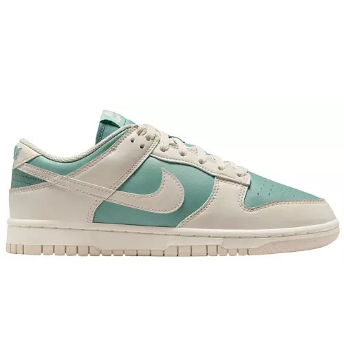 A pair of low-top sneakers in seafoam green and white with a prominent swoosh symbol on the side, featuring a white sole and perforations on the toe box.