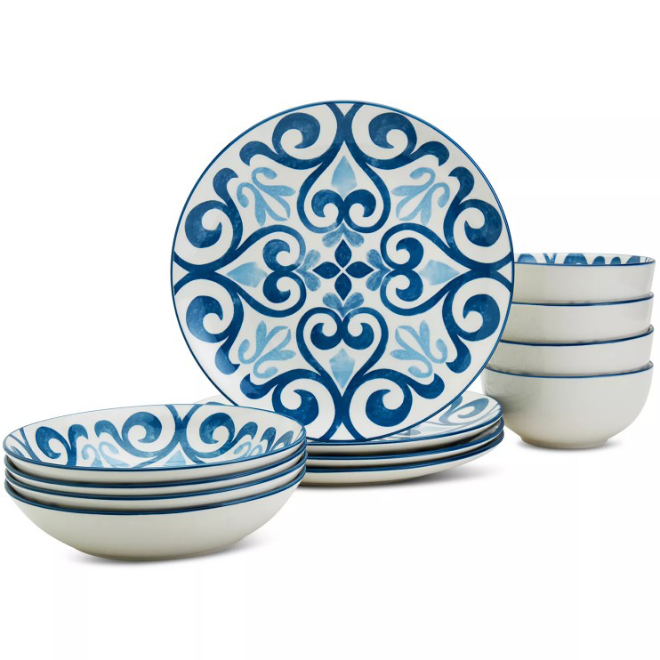 A dinnerware set featuring blue and white plates and bowls with ornate patterns. The design includes intricate, symmetrical blue swirls on a white background.