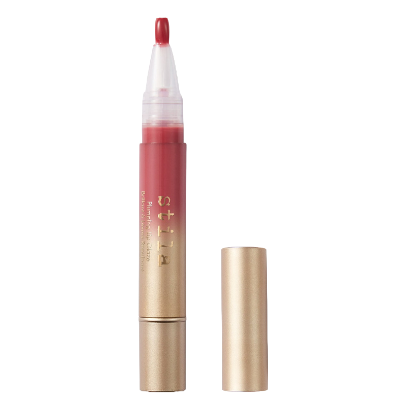 Stila Plumping Lip Glaze in a pen-like tube with a twist-up applicator, featuring a gold-colored cap and a visible red gloss.