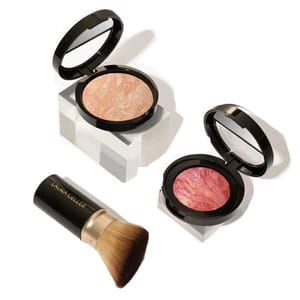A makeup set featuring two compact powders with marbled textures in peach and pink shades, accompanied by a brush labeled \“Laura Geller.\“