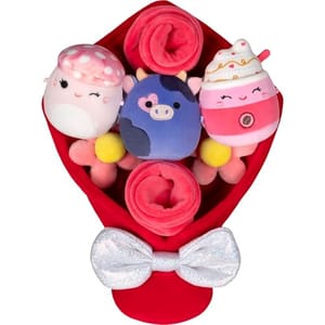 A plush bouquet featuring three cute, round stuffed animals, including a pink mushroom, a purple cow, and a pink drink, wrapped in a red and pink arrangement with a sparkly silver bow.