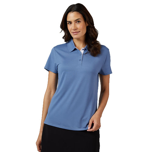 A woman wearing a short-sleeve, light blue polo shirt paired with a black skirt, posing against a plain white background.