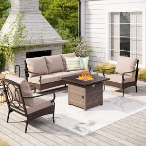 A 4-piece patio set featuring a cushioned sofa, two armchairs, and a fire pit table with a wicker base. The set is arranged on a deck with an outdoor fireplace and includes neutral-toned cushions.
