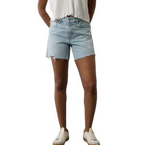 Relaxed denim shorts in light blue with a high waist, featuring a frayed hem and subtle distressed details. Paired with a white, cropped top and white sneakers.
