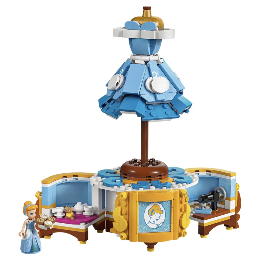 LEGO set featuring a miniature figure with accessories, including a blue gown, tea set, and sewing area, designed around a central rotating structure with decorative elements.