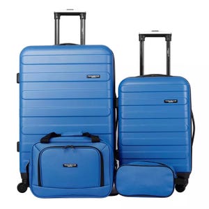 Blue 4-piece hardside luggage set includes two suitcases with wheels and telescoping handles, a carry-on bag, and a toiletry bag. All pieces feature a uniform design with horizontal grooves and \“Travelers Club\“ branding.