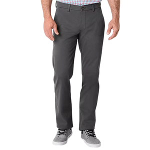 A person wearing dark gray straight-leg pants paired with light gray sneakers and a checkered shirt.